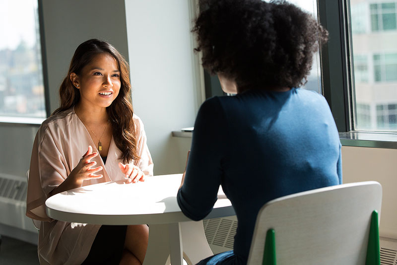 Two students speaking at a roundtable